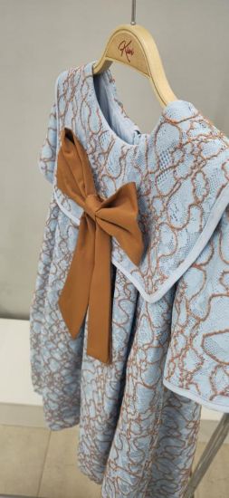 صورة فستان سماوي بفينكة كبيره على الصدر